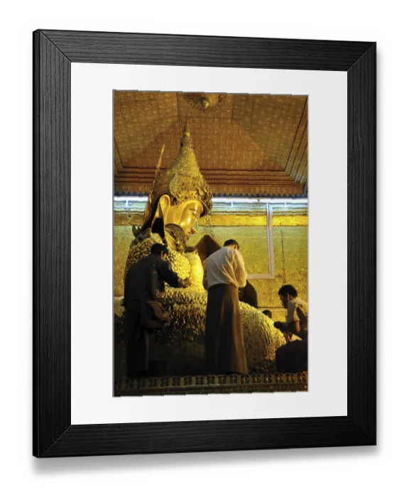 Framed Print : Believers sticking gold foil on a Buddha statue Framed Print : Believers sticking gold foil on a Buddha statue