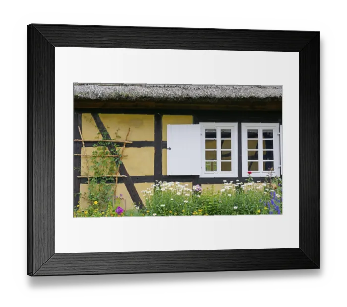 Framed Print : An old half-timbered house with flowers in front of it