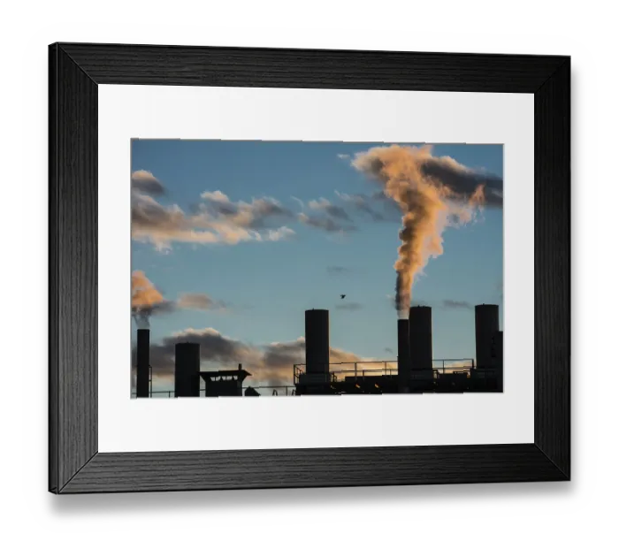 Framed Print : Air pollution from smokestacks of a factory in the sunset