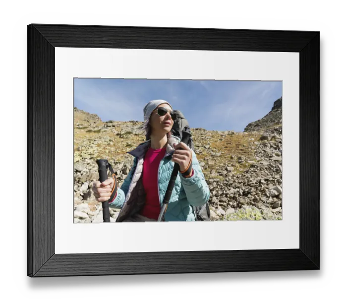 Framed Print : Hiker girl in sunglasses down jacket and hat with a backpack Framed Print : Hiker girl in sunglasses down jacket and hat with a backpack