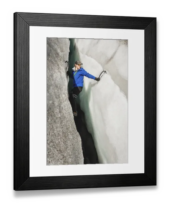 Framed Print : A free climber without insurance with two ice axes rises from a crack in the glacier Framed Print : A free climber without insurance with two ice axes rises from a crack in the glacier