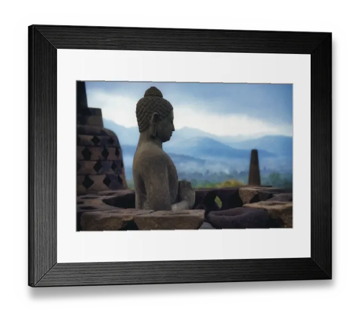 Framed Print : A Buddha statue sits carved in stone with mountains in the background Framed Print : A Buddha statue sits carved in stone with mountains in the background