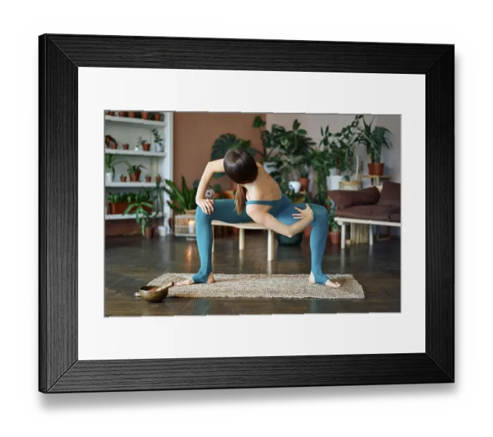Framed Print : Young sporty woman practicing yoga at home doing twisting variation exercise of goddess pose