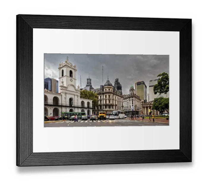 Framed Print : Different architectural styles meet under a cloudy sky in an urban space