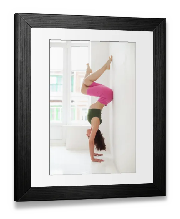 Framed Print : Full body of focused slim female female performing handstand near wall while practicing yoga in light room by Framed Print : Full body of focused slim female female performing handstand near wall while practicing yoga in light room by
