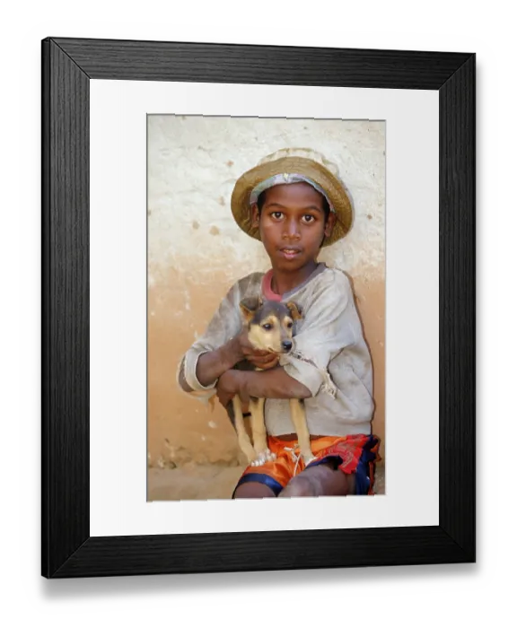 Framed Print : Boy with dog puppy on arm, Madagascar Framed Print : Boy with dog puppy on arm, Madagascar