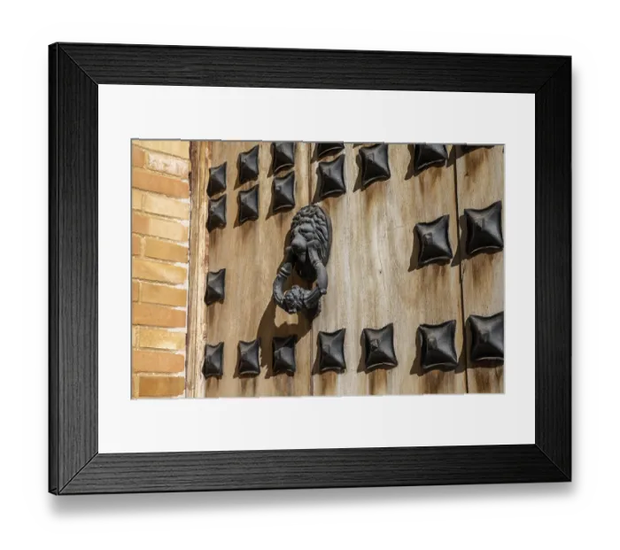 Framed Print : A massive wooden door with reinforced metal and old ornate lion door knocker