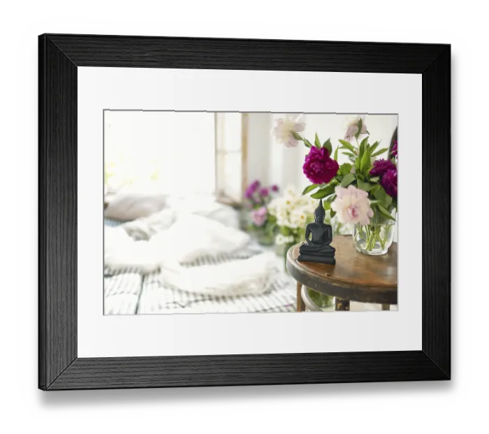 Framed Print : Black stone Buddha Figure On cozy light room background on the little table with peony flowers Framed Print : Black stone Buddha Figure On cozy light room background on the little table with peony flowers