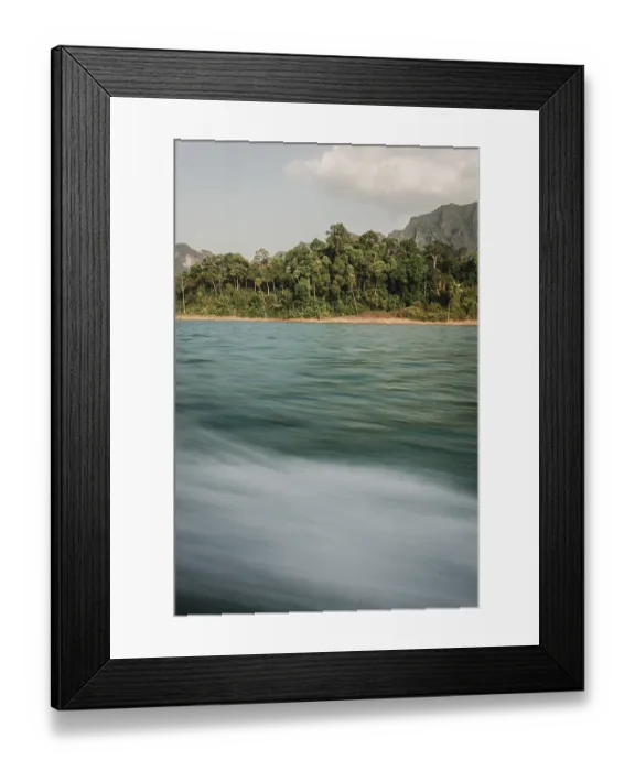 Framed Print : Moving water in front of a picturesque coastline with forest in the background Framed Print : Moving water in front of a picturesque coastline with forest in the background