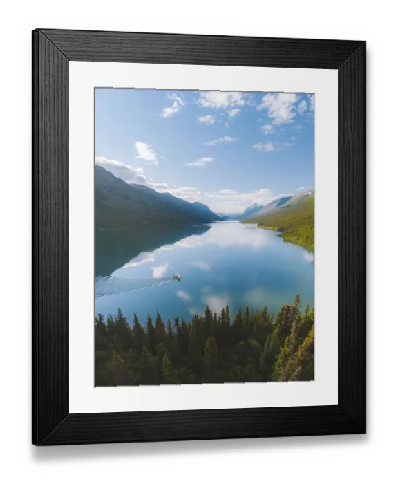 Framed Print : A tranquil lake reflecting the surrounding mountains and forest