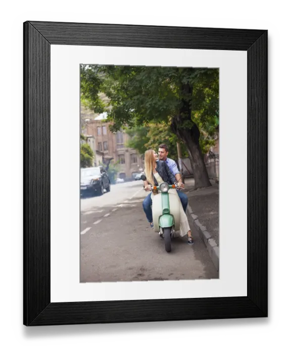 Framed Print : Happy young couple by a vintage scooter on the street
