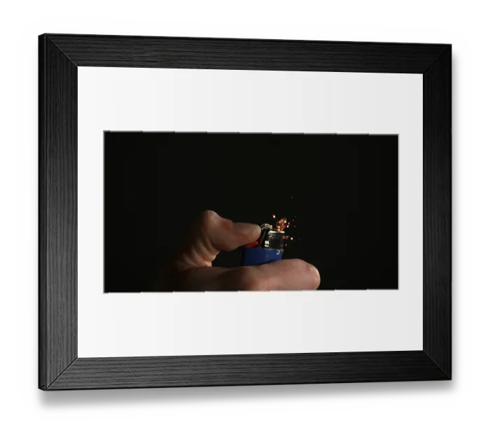 Framed Print : Lighter in Hand with Flame against Black background
