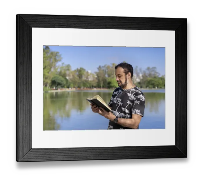 Framed Print : Mature man reading by a lake, enjoying free time on a sunny day