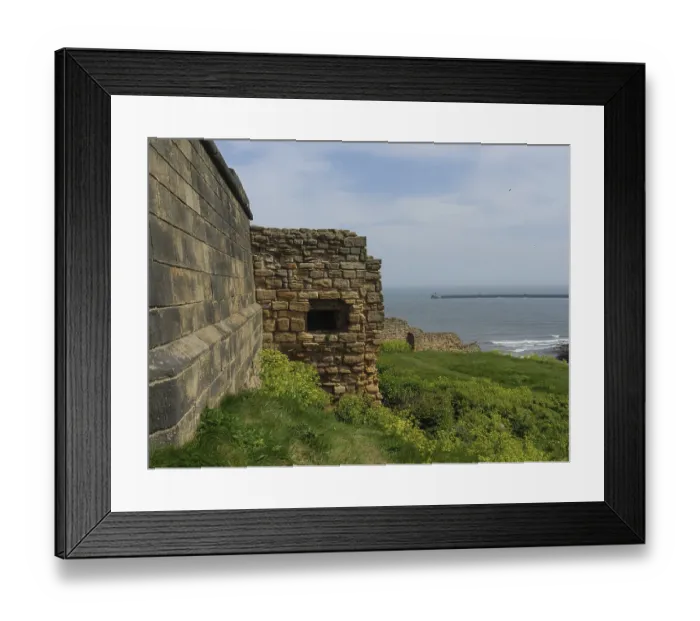 Framed Print : A historic fortress wall in front of the ocean on a sunny day with a green meadow in the foreground