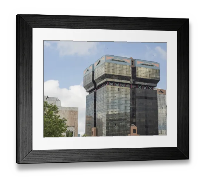 Framed Print : Modern high-rise building with glass facade and unique architecture under a clear sky