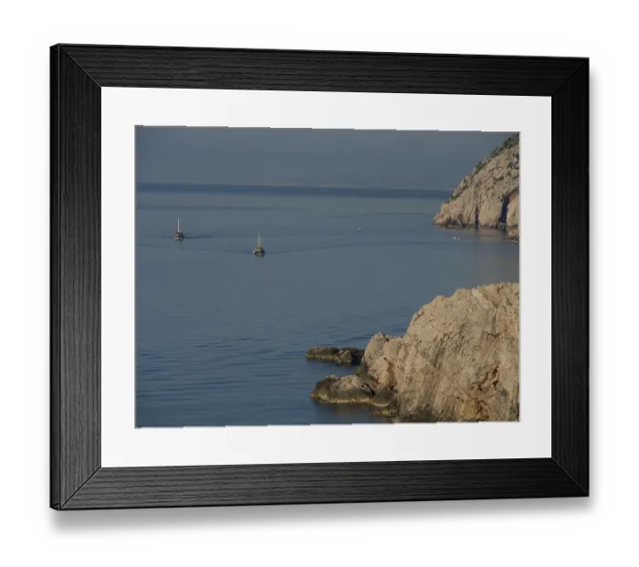 Framed Print : Two boats sail on the calm sea along a rocky coast