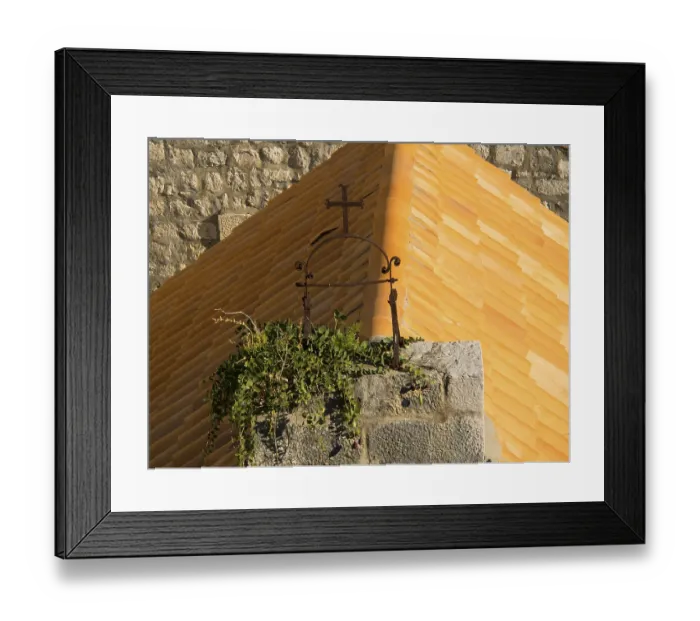 Framed Print : Historic cross on an overgrown roof in a medieval setting