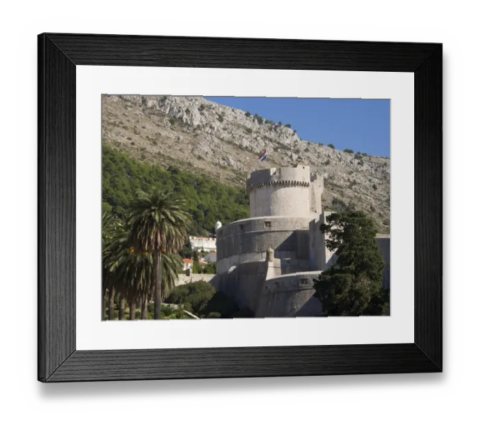 Framed Print : Massive medieval fortress with a national flag on a hill surrounded by trees Framed Print : Massive medieval fortress with a national flag on a hill surrounded by trees