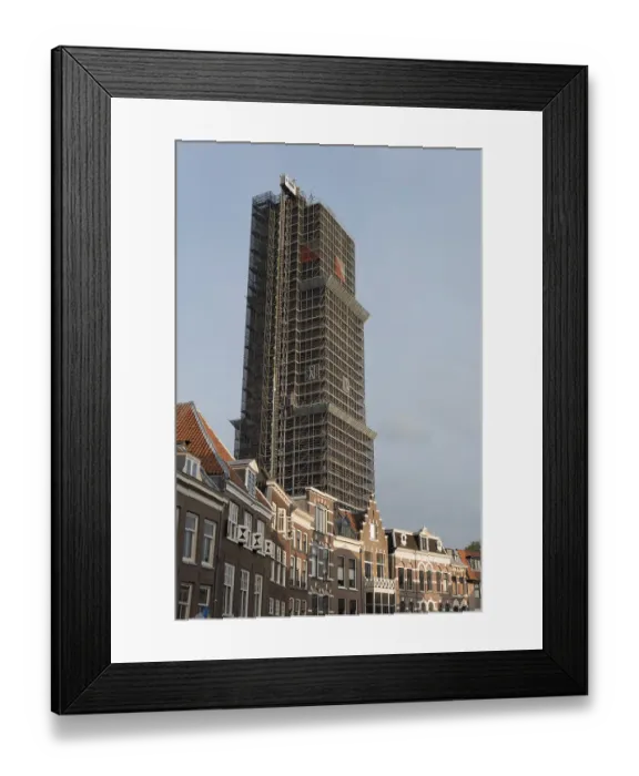 Framed Print : A high-rise building with scaffolding surrounded by traditional brick houses under a blue sky