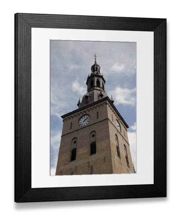 Framed Print : A tall church tower with a clock and gothic architecture under a blue sky Framed Print : A tall church tower with a clock and gothic architecture under a blue sky