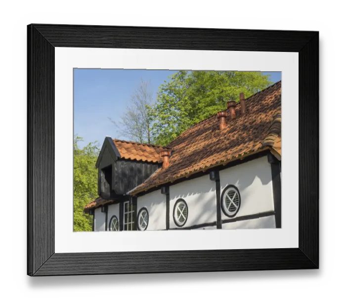 Framed Print : Half-timbered house with round window and tiled roof in a rural setting Framed Print : Half-timbered house with round window and tiled roof in a rural setting
