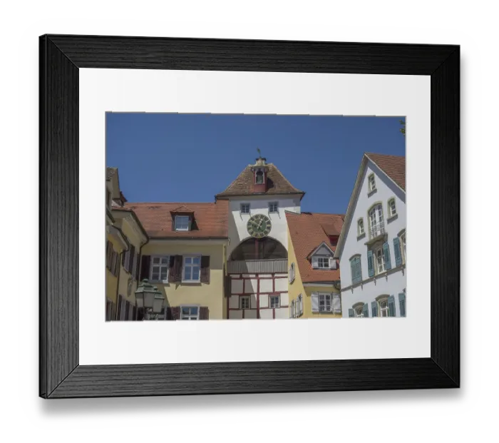 Framed Print : Half-timbered house with clock and church tower in the old town