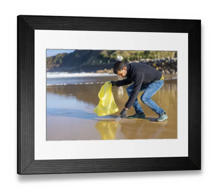 Framed Print : Volunteer man collecting garbage or plastic on the beach