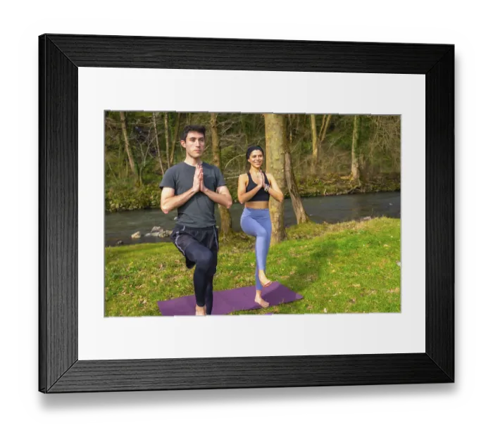 Framed Print : Man and woman practicing yoga tree pose by a river in a forest Framed Print : Man and woman practicing yoga tree pose by a river in a forest