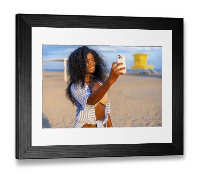 Framed Print : Young black woman taking selfie on beach using smartphone