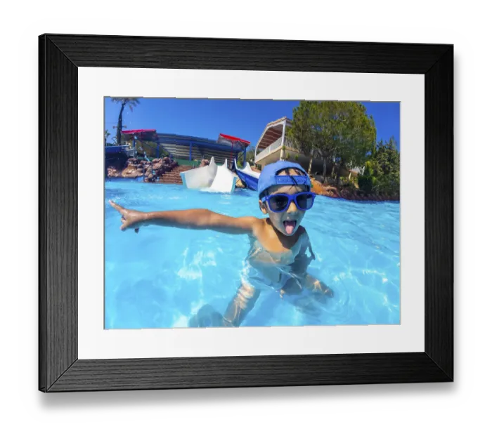 Framed Print : Playful child with blue sunglasses and hat pointing with finger