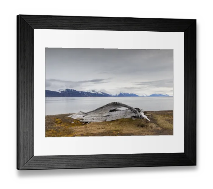 Framed Print : Broken wooden boat in front of mountain range