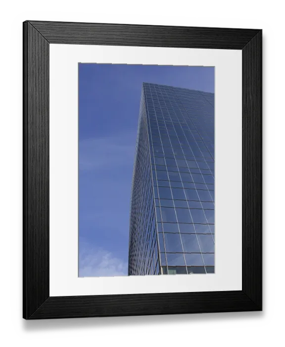 Framed Print : Windowed skycraper building against a blu sky with thin clouds Framed Print : Windowed skycraper building against a blu sky with thin clouds