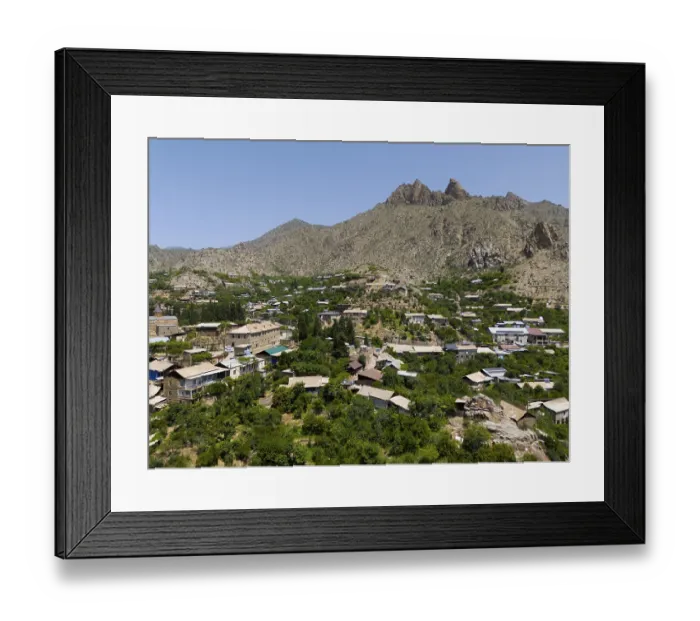 Framed Print : Village surrounded by lush vegetation and high mountains in a sunny landscape