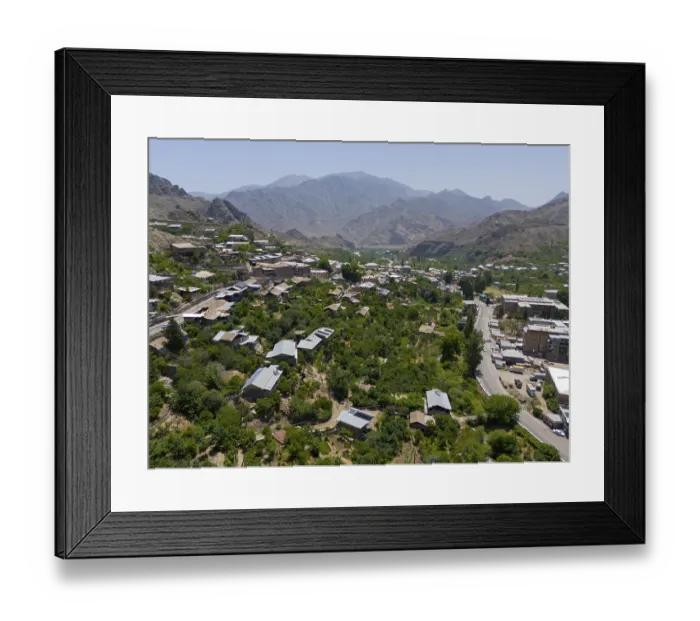 Framed Print : Panoramic view of a village along a road amidst green hills and mountains