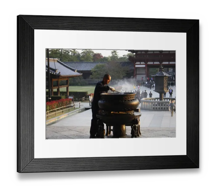 Framed Print : Closing time: an attendant clears away incense sticks at Todaiji temple in Nara city Framed Print : Closing time: an attendant clears away incense sticks at Todaiji temple in Nara city