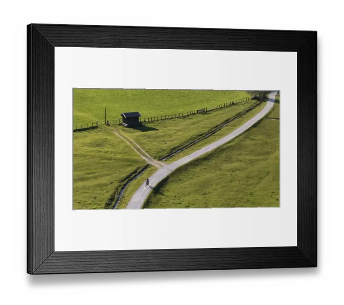 Framed Print : Woman riding an e-bike through the alpine landscape