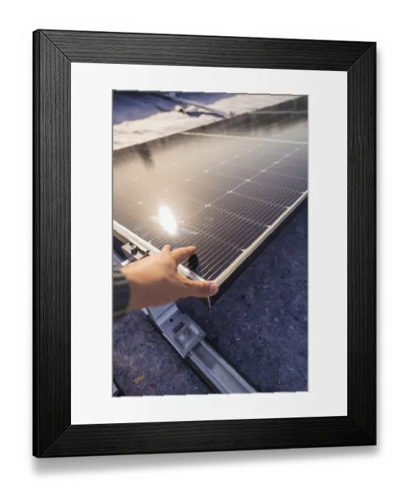 Framed Print : A hand adjusts a solar panel on a roof in the sunlight