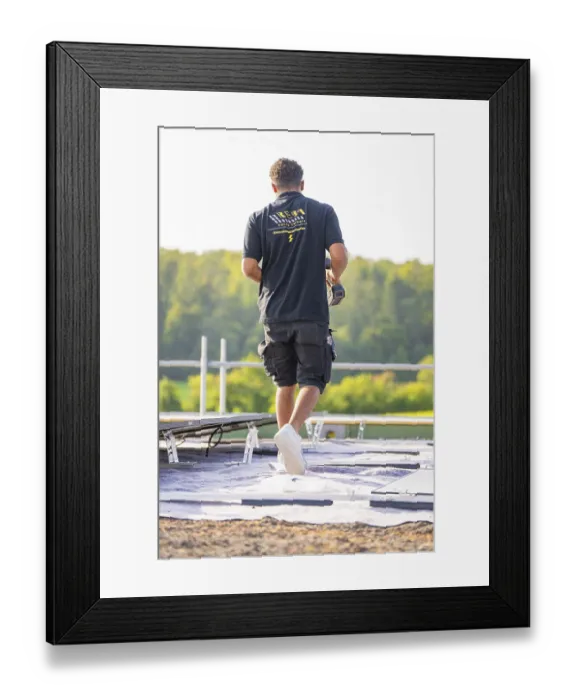 Framed Print : Back view of a worker with a drilling machine on a roof