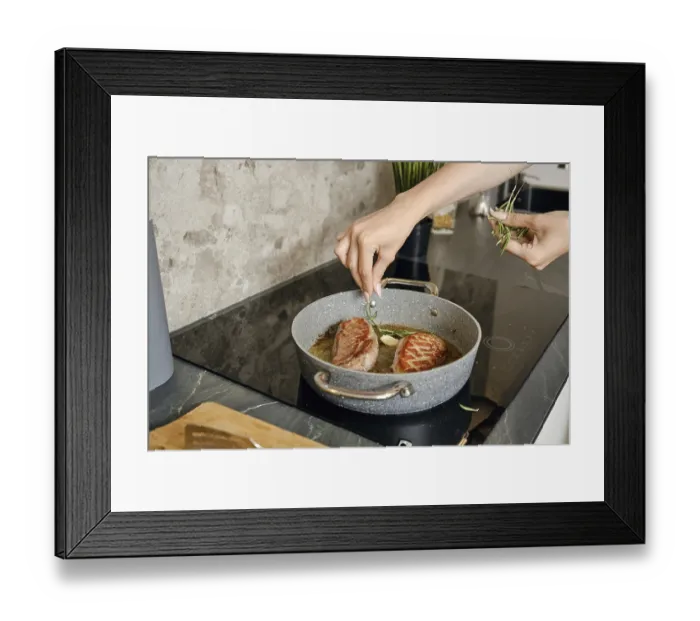 Framed Print : A person is preparing two pieces of duck breast in a frying pan