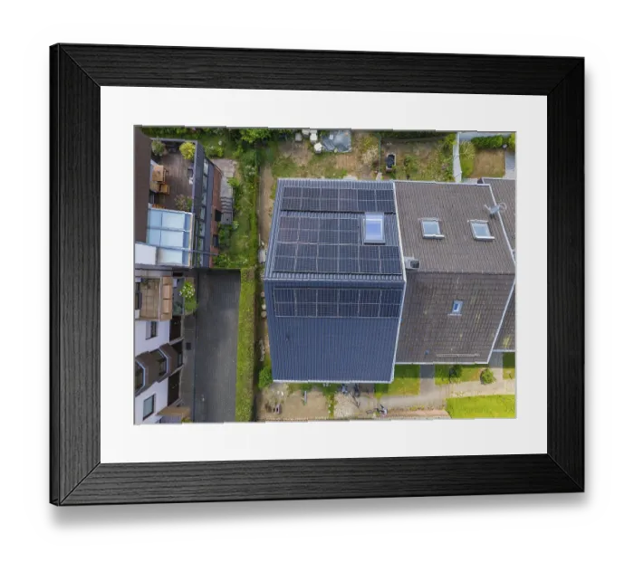 Framed Print : Bird's eye view of the roof of a house with solar panels with urban surroundings