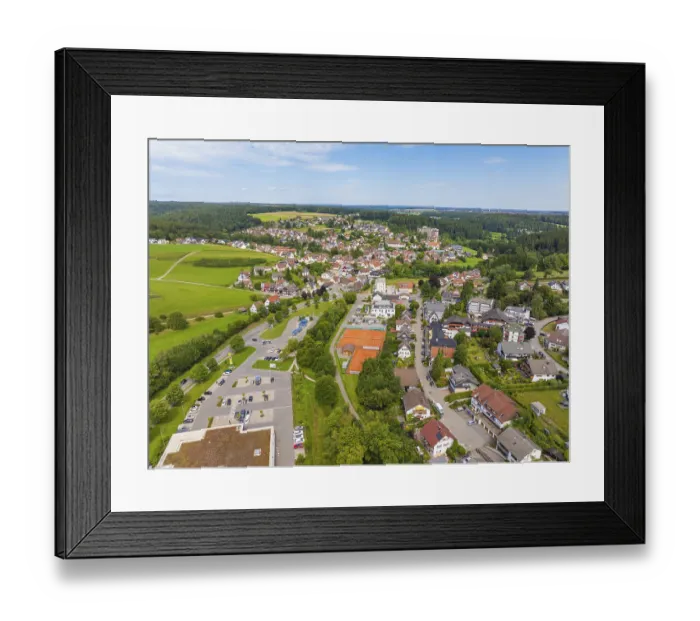 Framed Print : Aerial view of a picturesque village with green areas and the sky in the background