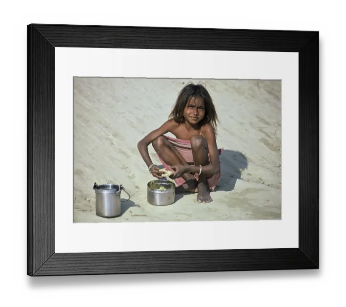 Framed Print : Girl at mealtime, squatting in the sand Framed Print : Girl at mealtime, squatting in the sand