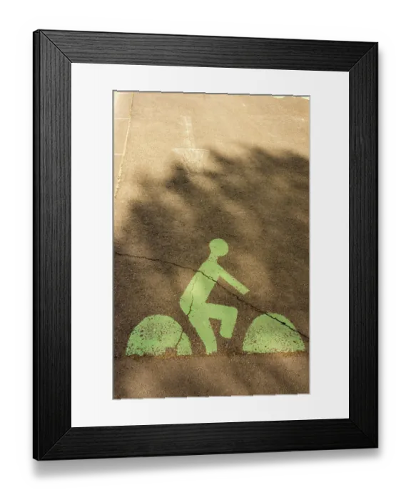Framed Print : A green bicycle lane marking is visible on a city street