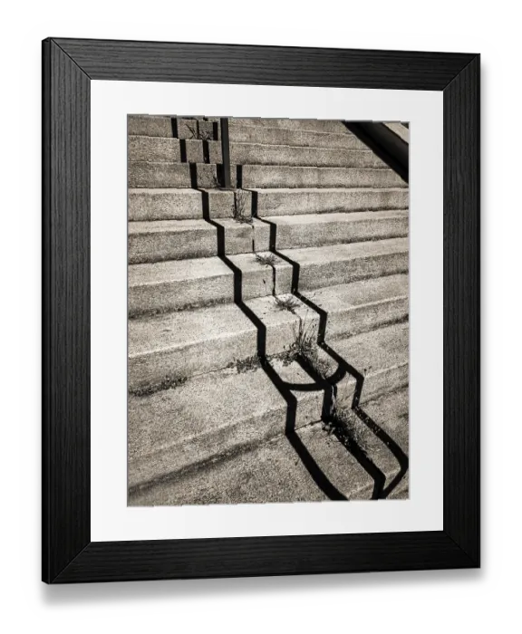 Framed Print : Uneven concrete steps in an urban area expose cracks filled with weeds growing in the crevices