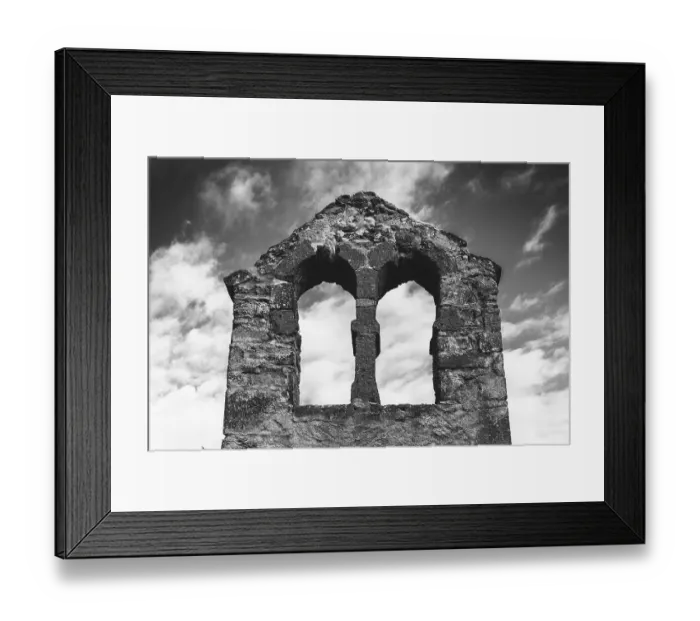 Framed Print : Crumbling stone ruins of a bell tower stand against a cloudy sky