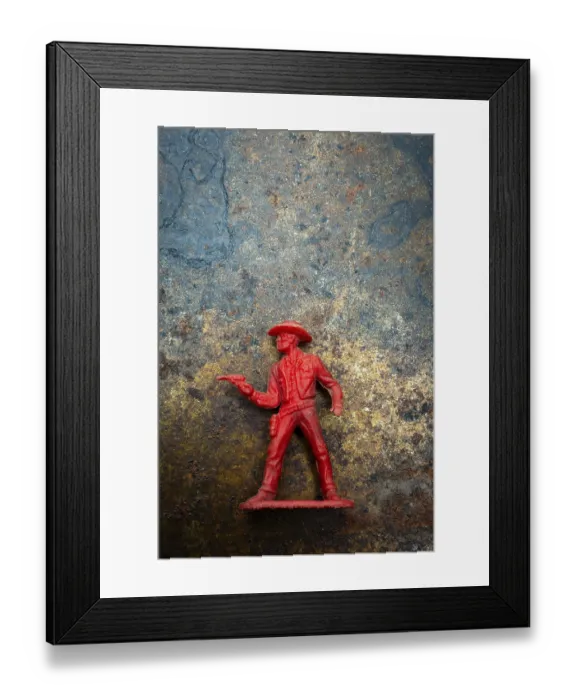 Framed Print : A red cowboy figure is positioned confidently with a raised finger