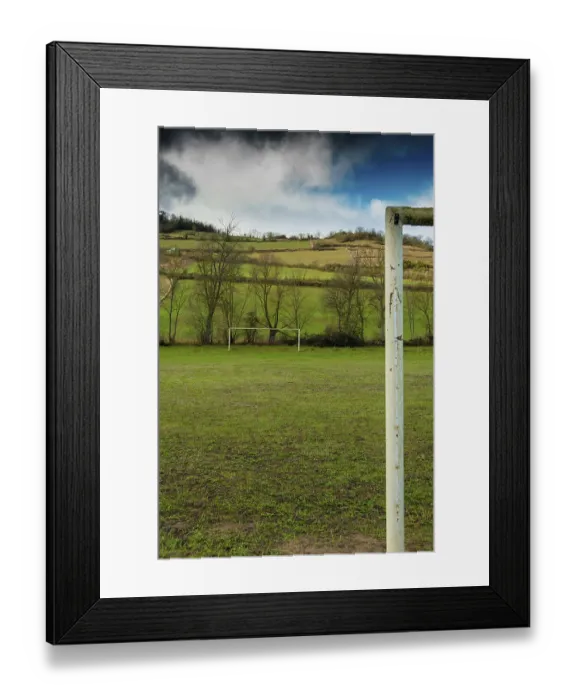 Framed Print : A football field is set against rolling hills and trees Framed Print : A football field is set against rolling hills and trees