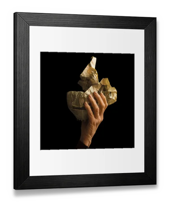 Framed Print : A hand grips a crumpled newspaper Framed Print : A hand grips a crumpled newspaper