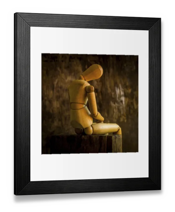 Framed Print : A wooden mannequin is positioned on a rough wooden surface Framed Print : A wooden mannequin is positioned on a rough wooden surface
