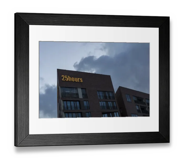 Framed Print : Modern architecture, neon sign on the facade of the 25hours Hotel in front of a cloudy sky at dusk